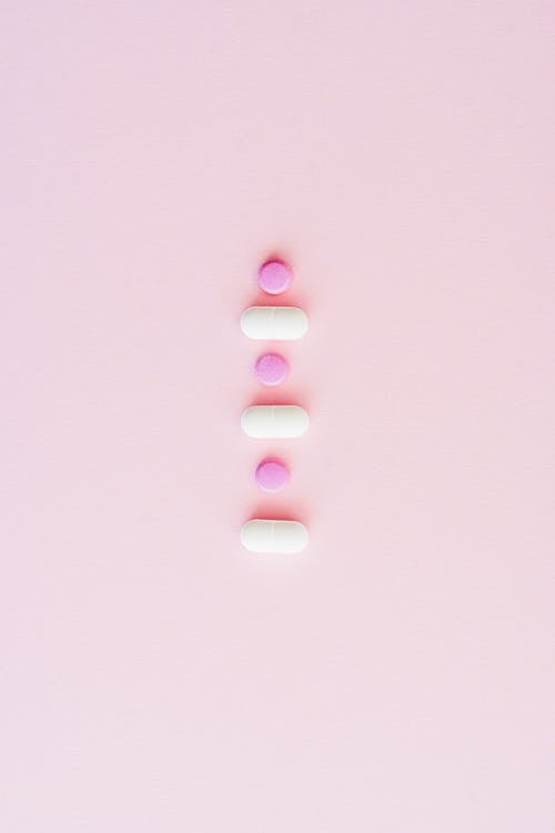 Lined Up Medicines on Pink Surface