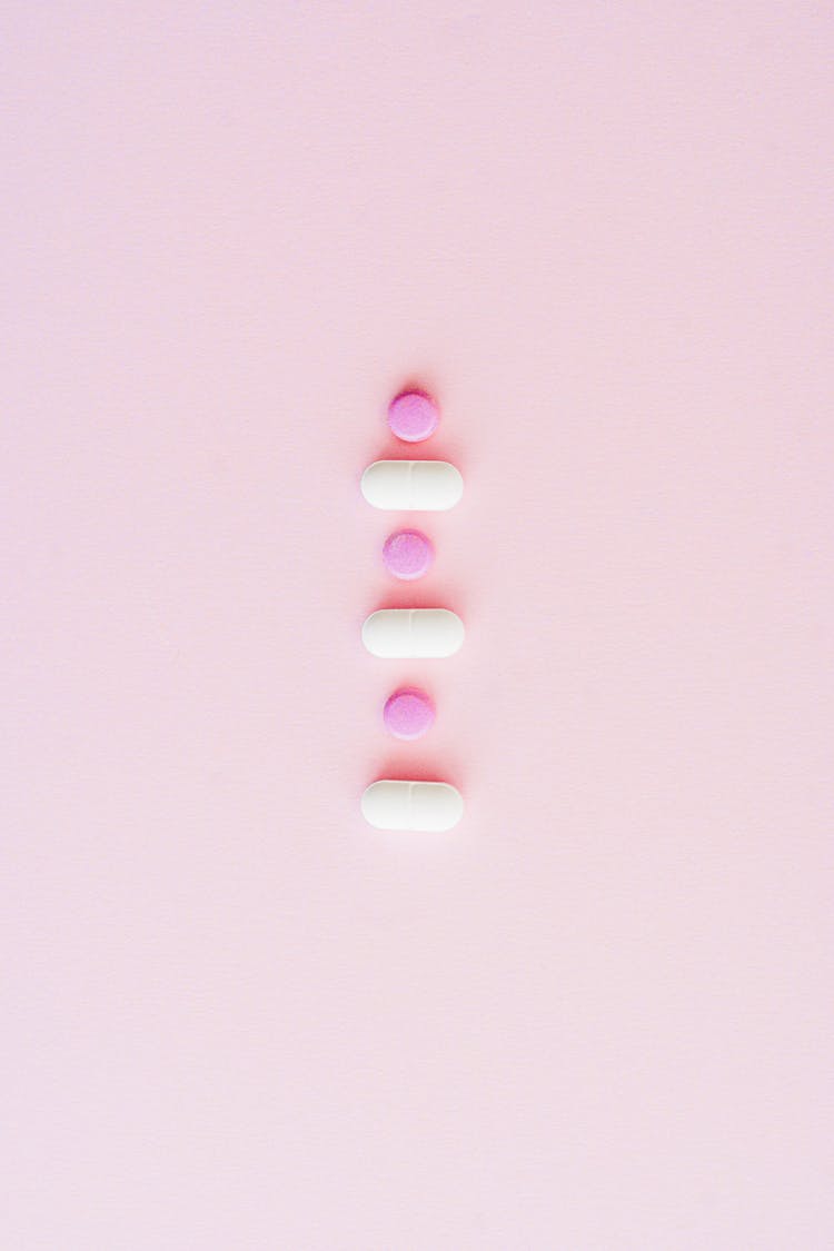 Lined Up Medicines On Pink Surface