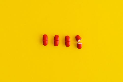 Orange Pills on Yellow Surface