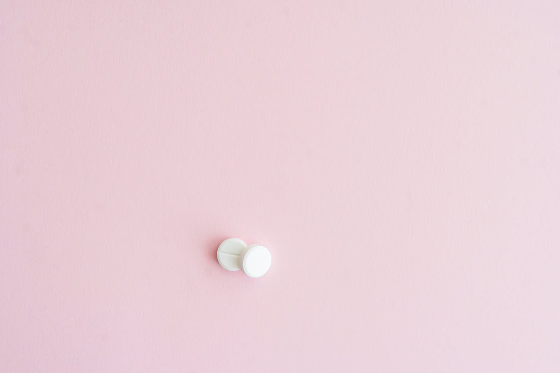 White Tablets on Pink Surface