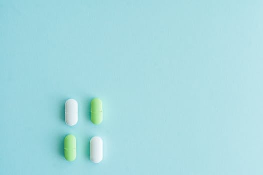 Four pills, green and white, arranged on a vibrant blue background.