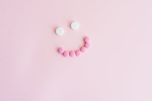 Pink and White Pills on Pink Background