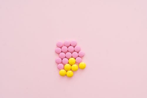 Free Pink and Yellow Pills on Pink Back Ground Stock Photo