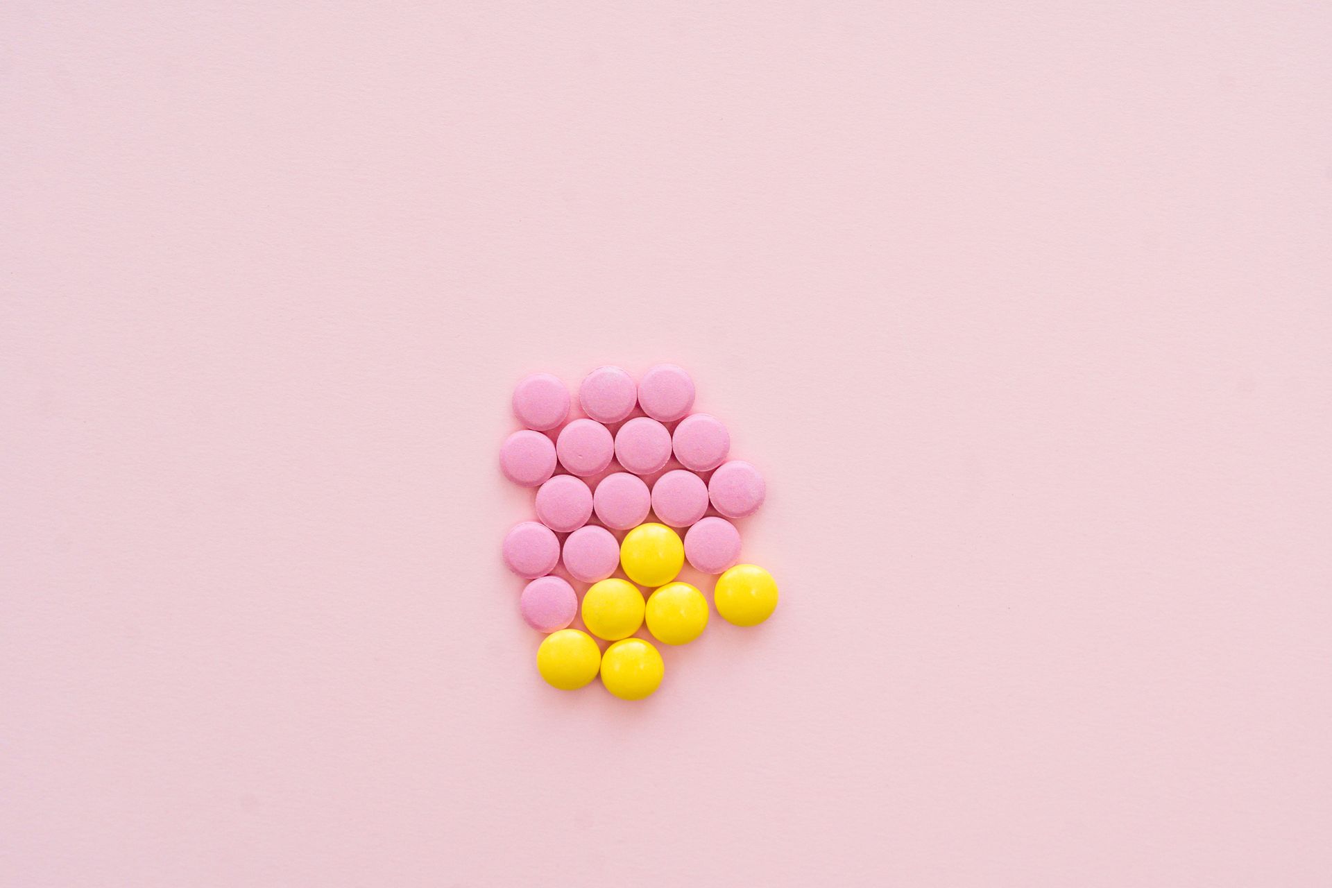 Pink and Yellow Pills on Pink Back Ground