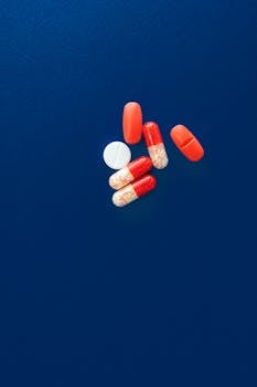 Assorted capsules and tablets on a bold blue background with copy space.