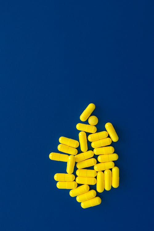 Yellow Capsules on a Dark Blue Surface