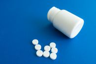 White Medication Pill on Blue Textile