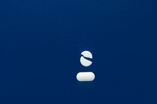Free White Pills on Blue Surface Stock Photo