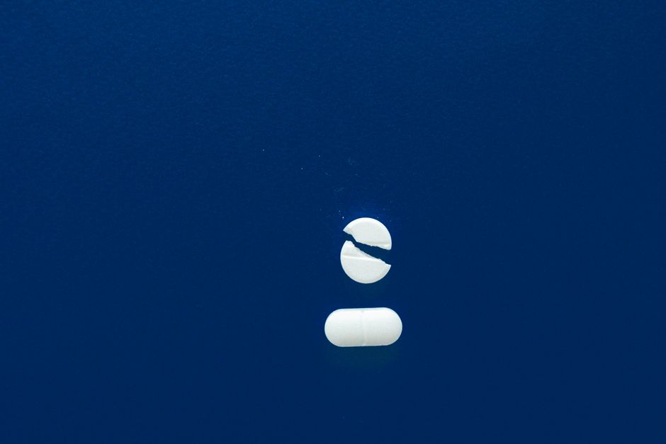 A single pill on a blue surface — absolute contraindications for ibogaine include cardiac conditions, SSRIs, methadone, and acute psychiatric instability