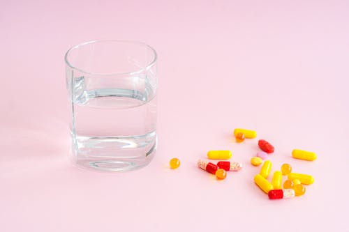 antibiyotik, bir bardak su, haplar içeren Ücretsiz stok fotoğraf