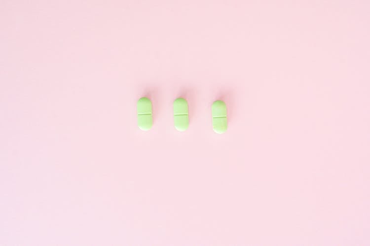 Medicine Tablets Arranged On Pink Surface