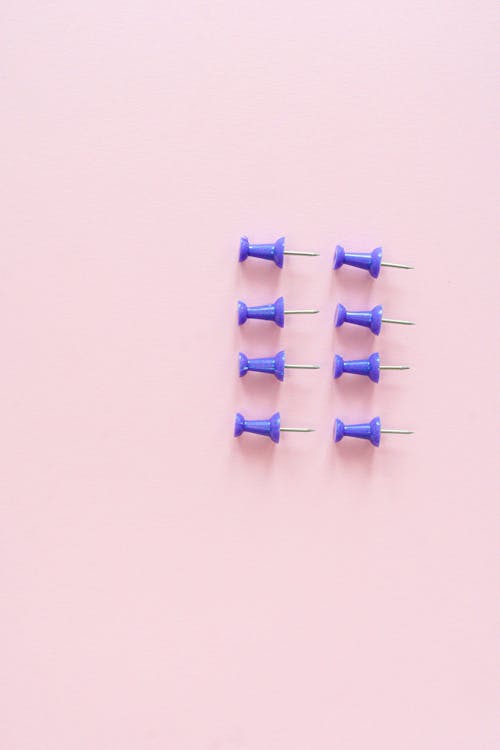 Blue Drawing Pins on Pink Background