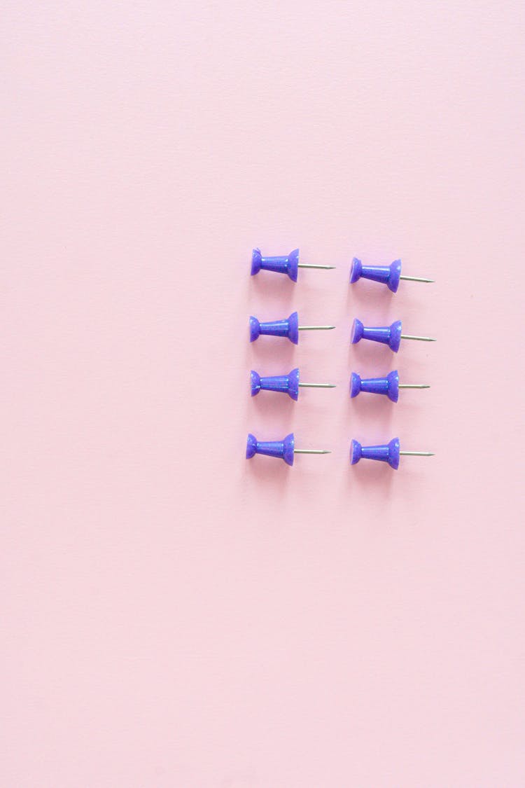 Blue Drawing Pins On Pink Background