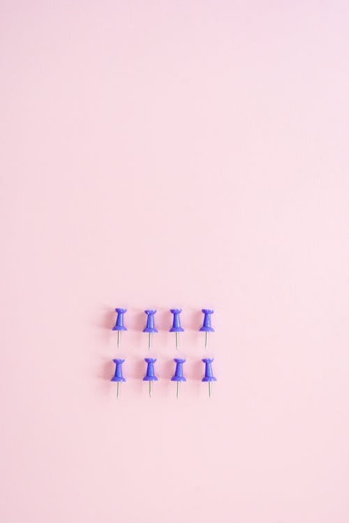 Push Pins on Pink Surface