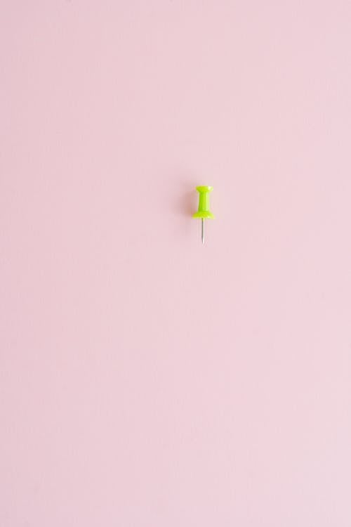 Free A Single Push Pin on Pink Surface Stock Photo