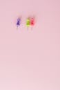 Close-Up Shot of Thumb Tacks on Pink Surface