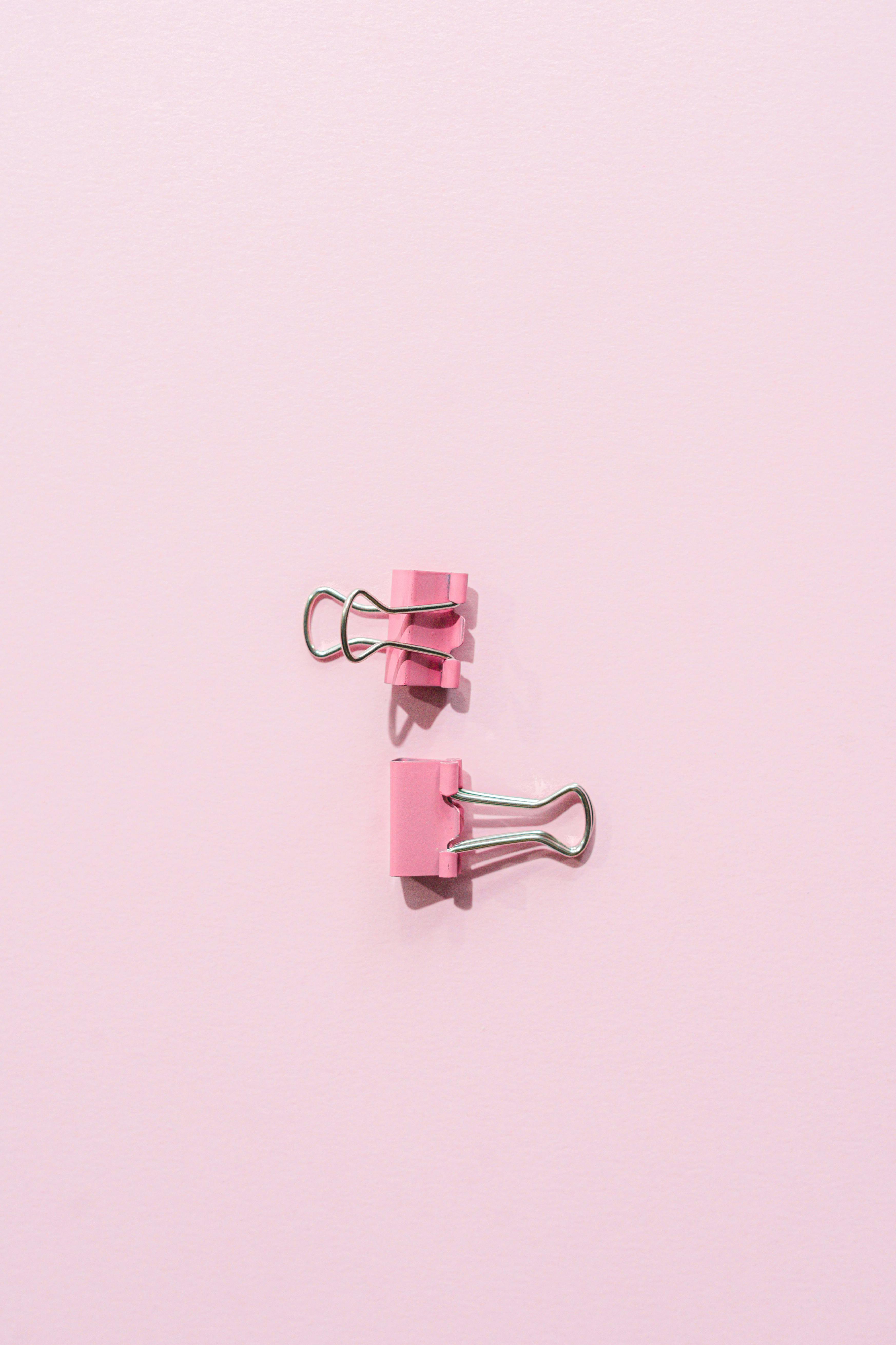 binder clips on a pink surface