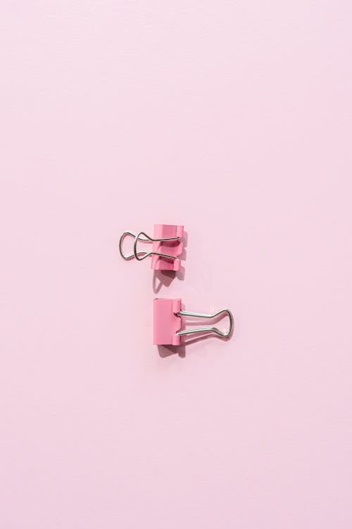 Foto profissional grátis de clipes de fichário, material de escritório, superfície rosa