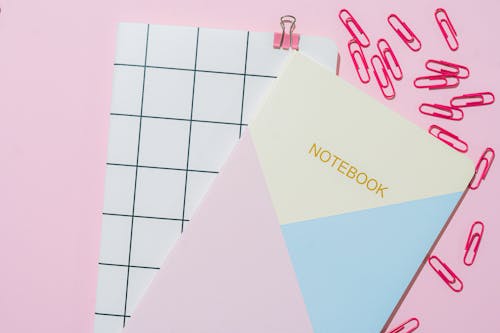 Free Pink Paper Clips and Notebooks on Pink Background Stock Photo