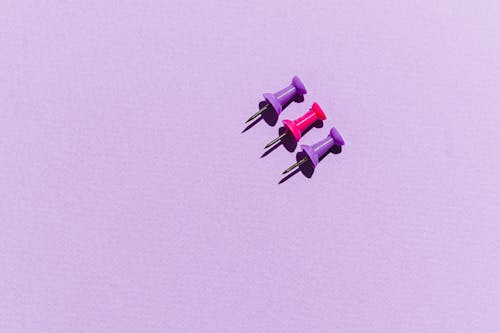 Push Pins on Purple Background