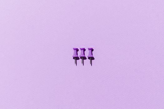 Close-Up Shot of Thumb Tacks on Purple Surface

