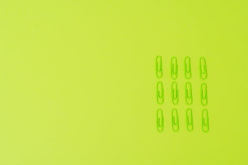 Green Paper Clips on Yellow Green Background