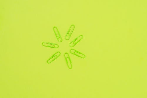 Free Green Paper Clips on Green Surface Stock Photo