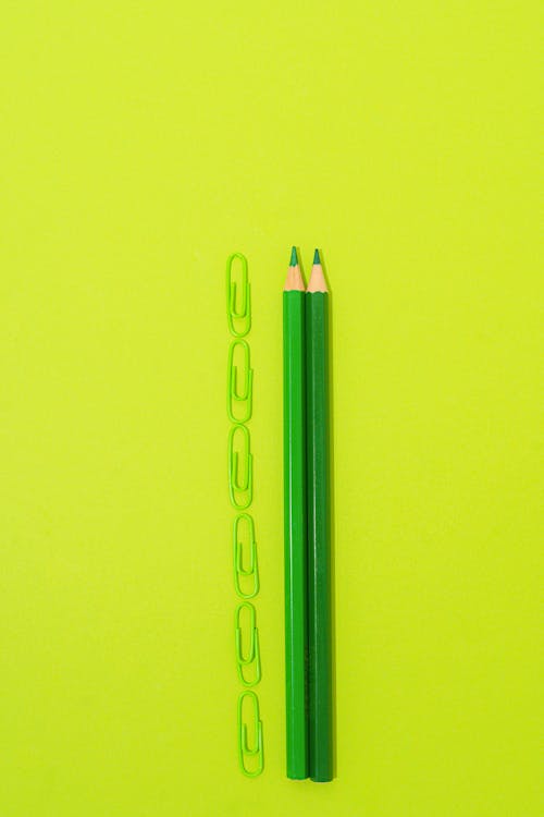 Paper Clips and Colored Pencils on Yellow background