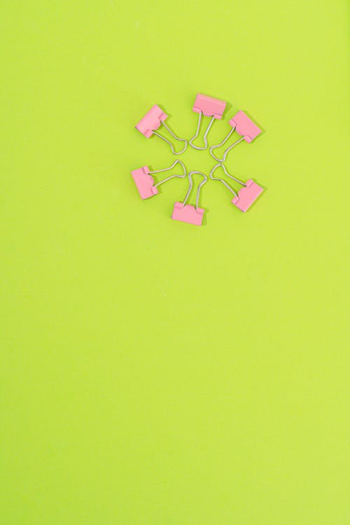 Pink Binder Clips on a Green Surface