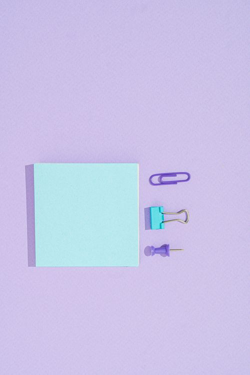 Free Pastel office supplies arranged on a purple surface for creative designs. Stock Photo