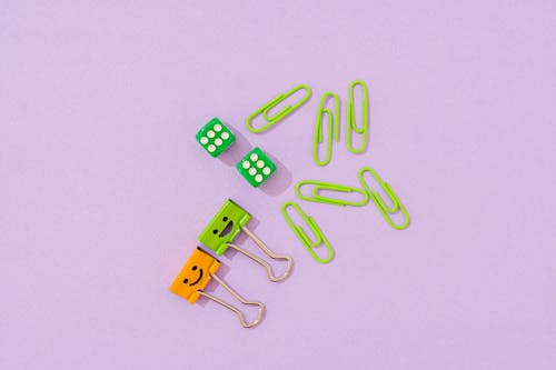Paper Clips and Dice on Purple Surface