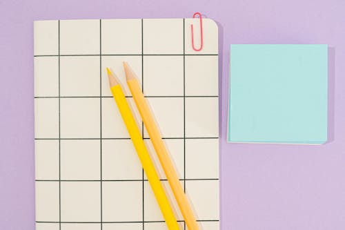 Free Yellow Colored Pencils on the Top of a Notebook Stock Photo
