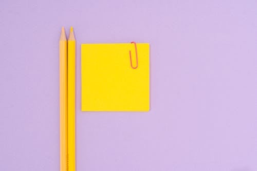 Free Sticky Notes With Paper Clip Beside Color Pencils Stock Photo