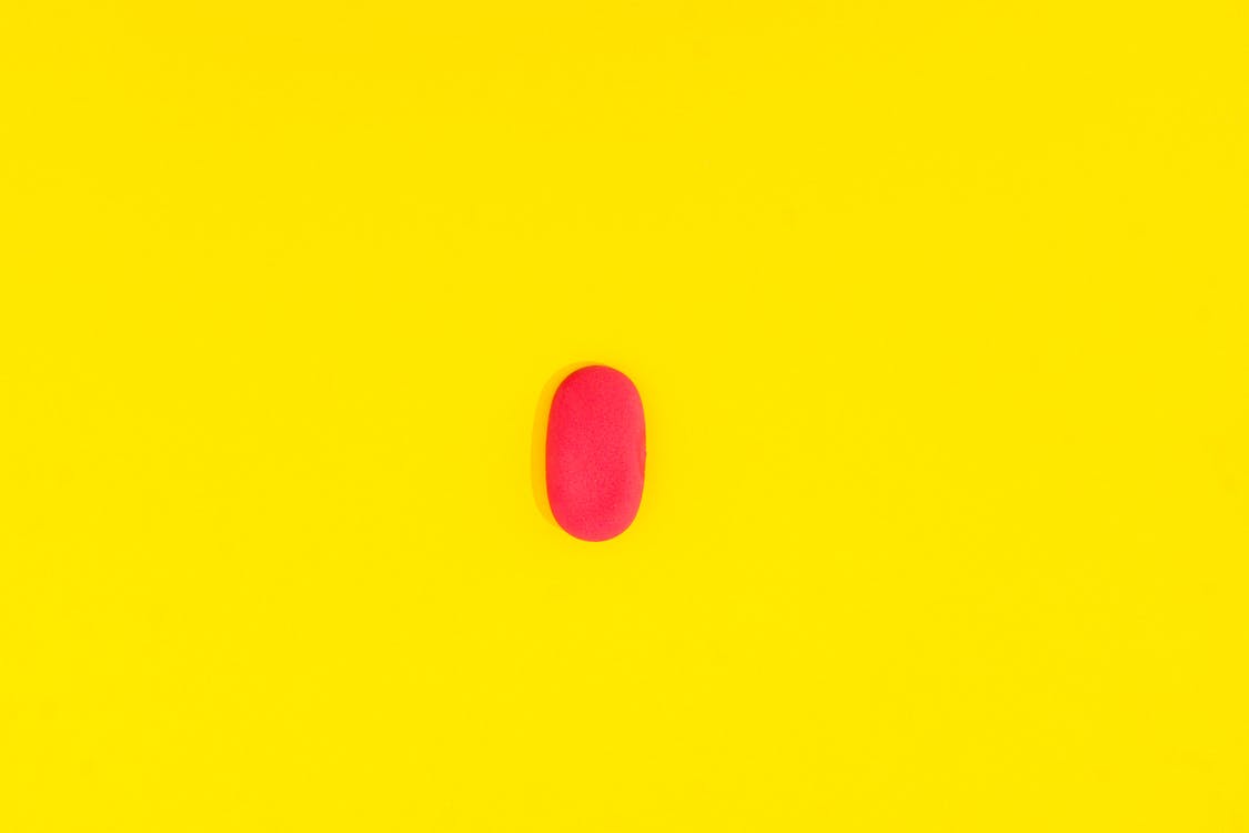 Red Capsule on Yellow Background
