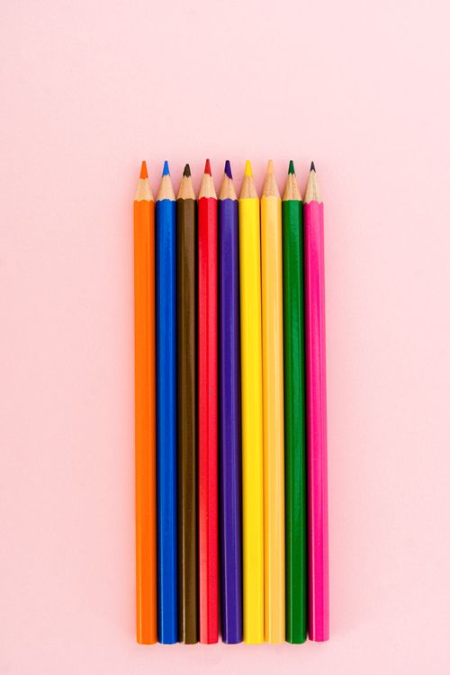 Free A colorful set of pencils neatly arranged on a light pink surface. Stock Photo