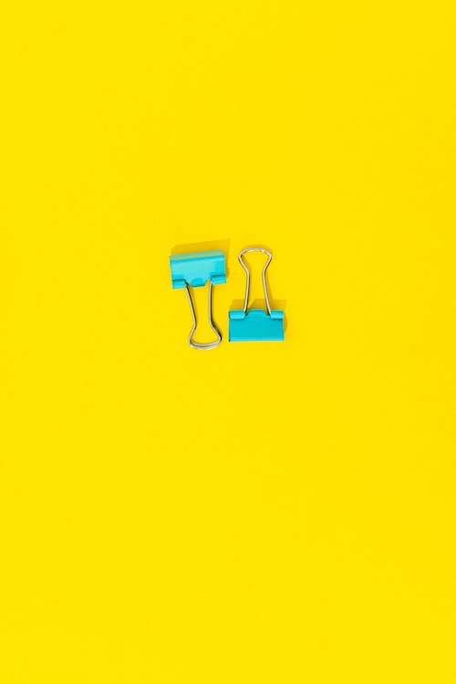 Teal Binder Clips in Yellow Background