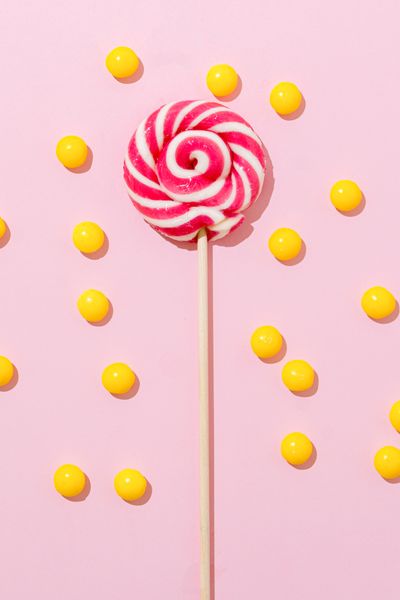 Lollipop and yellow candies on a plate — photo by SHVETS production on Pexels