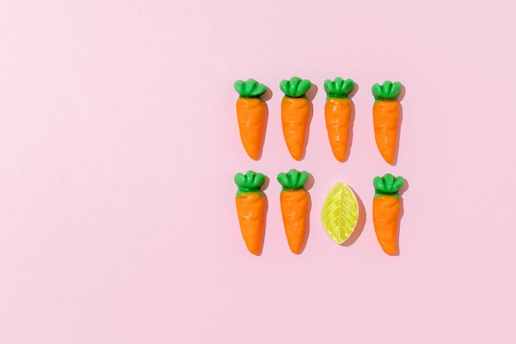 Carrots And Lemon Candies On Pink Background