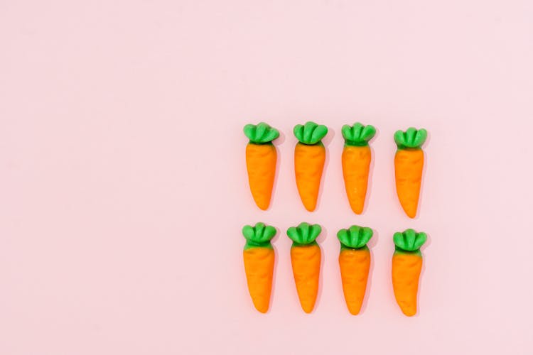 Carrots Design Candies On A Pink Surface