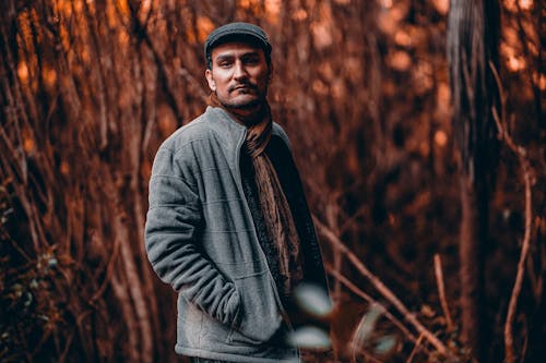 Man in Gray Jacket Standing Near Trees