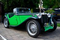 Green Classic Car Parked on Gray Concrete Pavement