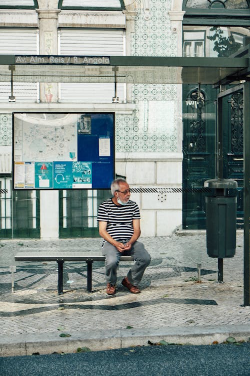 Man in Black and White Striped Shirt  Denim Jeans Sitting on Bench 