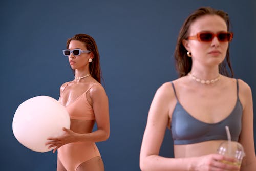 Free Two Women in Swimsuits Wearing Sunglasses Stock Photo