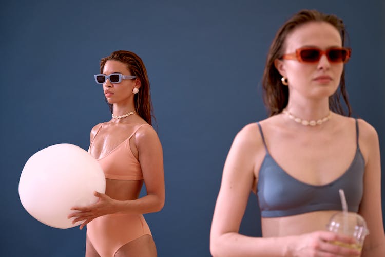 Two Women In Swimsuits Wearing Sunglasses