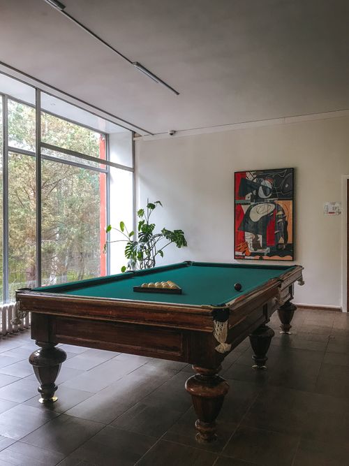 Free Classic billiard table in a stylish interior with a large window and modern art. Stock Photo
