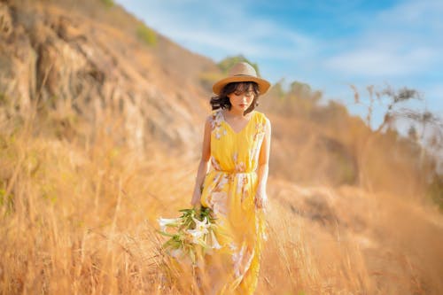 Free A Woman Wearing a Floral Dress and a Hat Stock Photo
