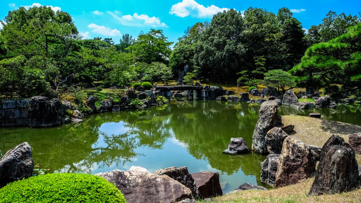 Tranquil Japanese strolling garden with pond and rocks, similar to the Kinkaku-ji garden grounds