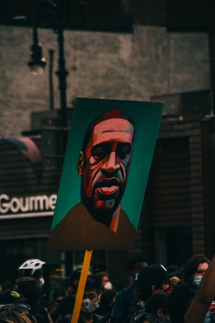 A vibrant art poster prominently displayed during a peaceful protest gathering.