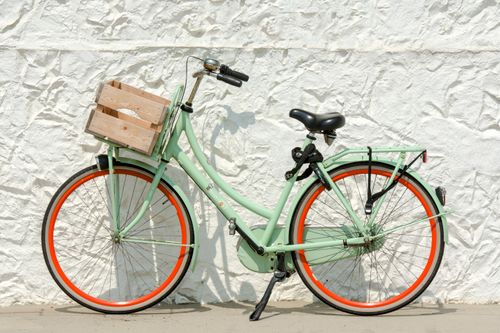 Free Mint green bicycle with wooden crate against a textured white wall. Stock Photo