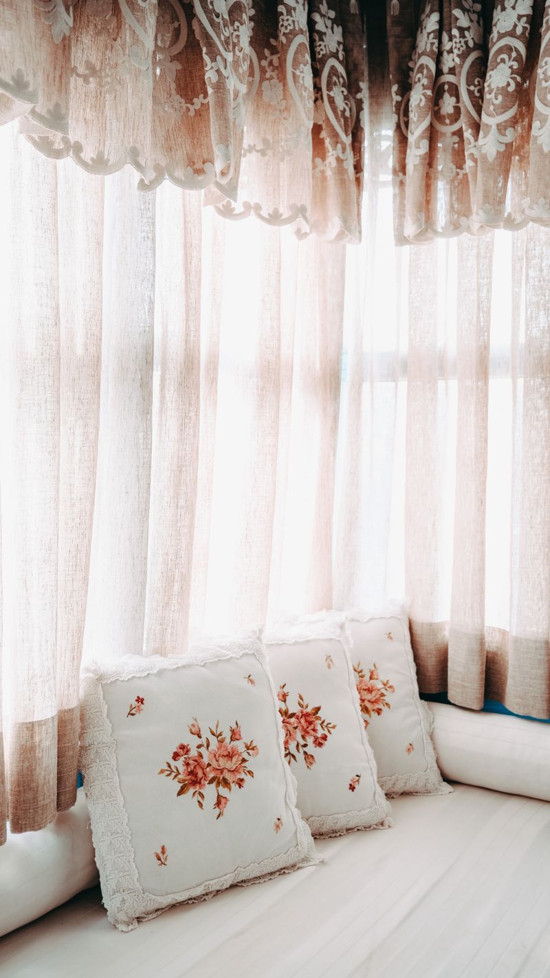 Window seat with cushions and patterned curtains
